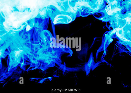 Dense blue smoke on a black isolated background. Background of smoke vape Stock Photo