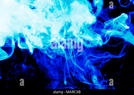 Dense blue smoke on a black isolated background. Background of smoke vape Stock Photo