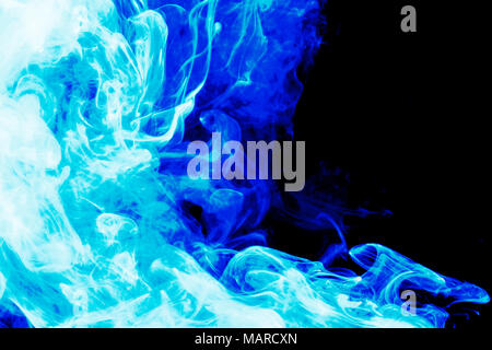 Dense blue smoke on a black isolated background. Background of smoke vape Stock Photo