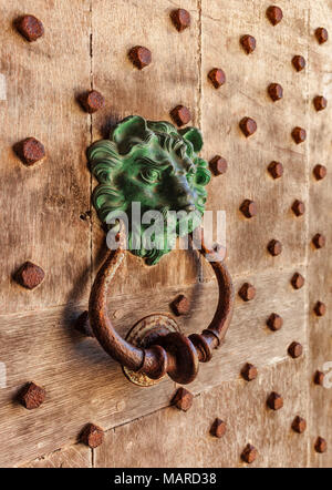 Lions head door knocker, on medieval studded oak door. Stock Photo