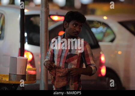 Bangalore, India - October 16, 2016: An unknown street side vendor, stands looking for customers this evening at MG Road, Bangalore. Stock Photo