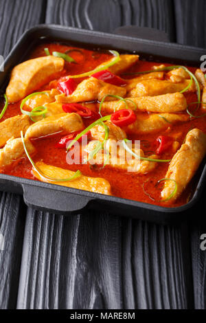 Thai style chicken panang curry close-up on a black plate on the table. vertical Stock Photo