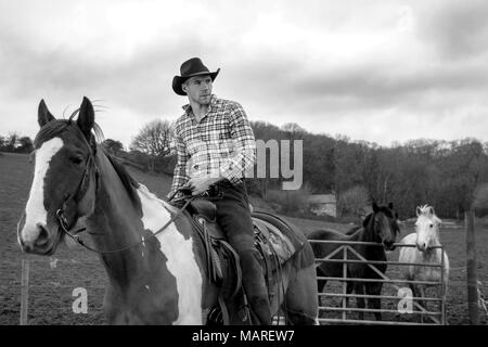 Silhouette of Cowboy Sitting on Fence, Rear View Stock Photo - Alamy