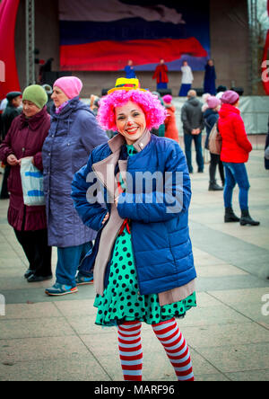 Funny playful girl clown in a colorful pink wig for the occasion. Stock Photo