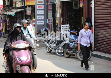 Bangalore, India - October 20, 2016: A close view of Mosque Road in Shivajinagar area. An unknown woman in uniform heading to her job. Stock Photo