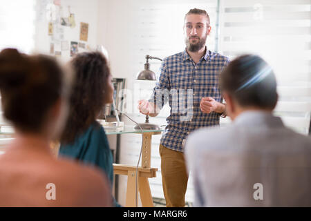 hipster man presenting his project. he is applauded by his colleagues Stock Photo