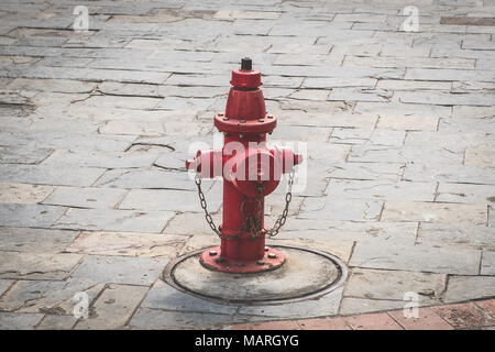 old hydrant on street - vintage red hydrant - Stock Photo