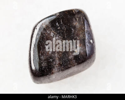 macro shooting of natural mineral rock specimen - polished anthophyllite gemstone on white marble background from Tirol, Austria Stock Photo