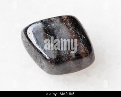 macro shooting of natural mineral rock specimen - pebble of anthophyllite gemstone on white marble background from Tirol, Austria Stock Photo