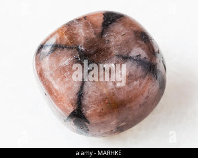 macro shooting of natural mineral rock specimen - polished Chiastolite gemstone on white marble background Stock Photo