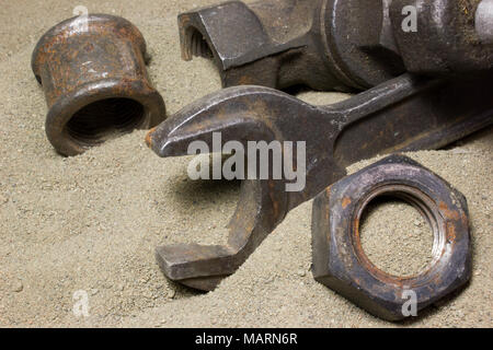 Old wrench and nuts on the sand Stock Photo