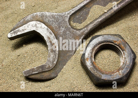Old wrench and nuts on the sand Stock Photo