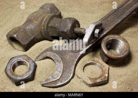 Old wrench and nuts on the sand Stock Photo