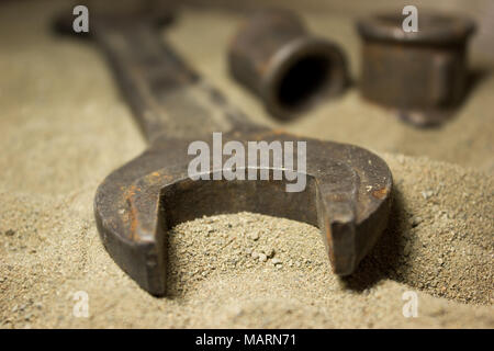 Old wrench and nuts on the sand Stock Photo