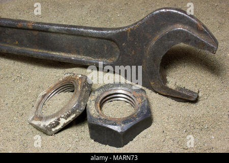Old wrench and nuts on the sand Stock Photo