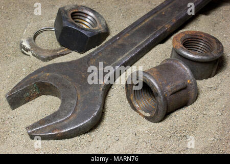 Old wrench and nuts on the sand Stock Photo