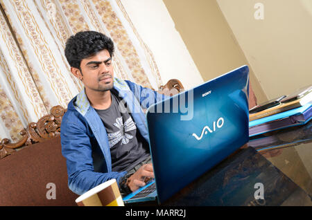 Young man working on laptop at home Stock Photo