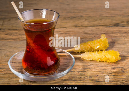 Close Up Of Saffron Rock Candy Sugar Crystal in Black Tea Cup Is Often Used To Be Dissolved In Tea In Iranian Persian Cuisine Stock Photo