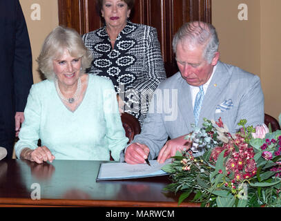 The Prince of Wales and the Duchess of Cornwall sign the visitors book at Old Government House in Brisbane, Australia. Stock Photo