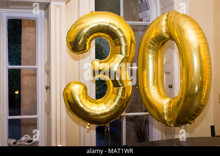 Golden number 30 thirty made of inflatable balloons, private party at home. Stock Photo