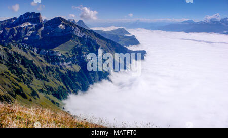 mountain landscape on a beautiful summer day with thick cloud cover in the valleys far below Stock Photo