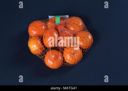 Small Oranges in a plastic netting bag. Stock Photo
