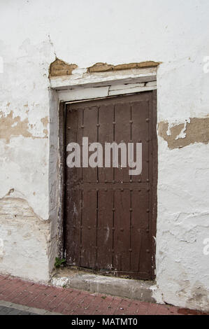 old wooden door on a white facade of a house Stock Photo