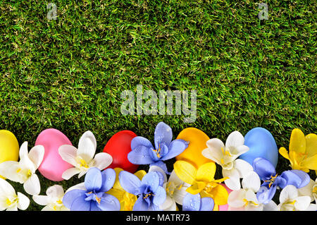 Easter background with hand painted eggs hidden in flowers with copyspace. Stock Photo