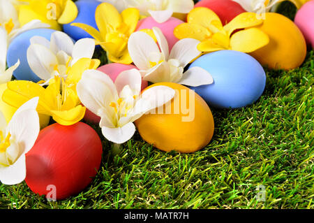 Easter background with hand painted eggs hidden in flowers Stock Photo