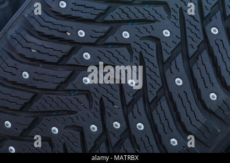Close-up of a studded tire profile with spikes for winter driving on ice and snow Stock Photo