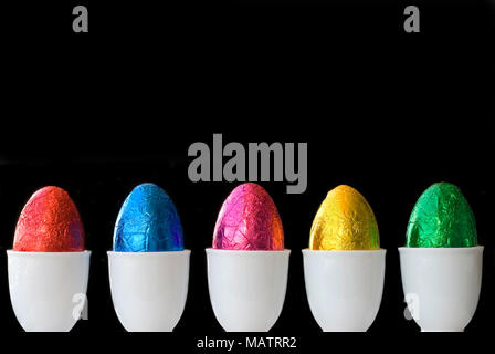 A line of colourful eggs.  Space for copy on black background Stock Photo