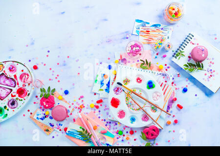 Header with an artist palette with sweets, sprinkles and candies in a creative party concept. Celebration flat lay with pink macarons and confetti. Co Stock Photo
