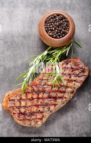 Grilled beef steak on stone board with spices Stock Photo