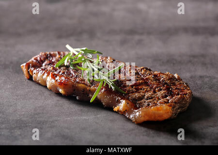 Grilled beef steak on stone board with spices Stock Photo