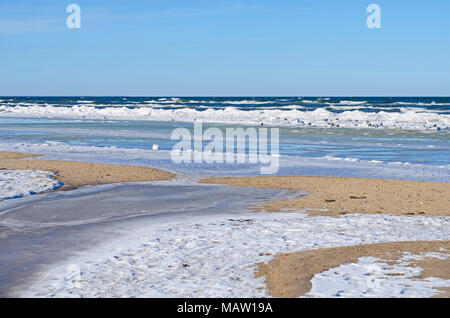 many color shades, shapes and structures of snow, ice and water at the sandy shore of Baltic sea in winter Stock Photo