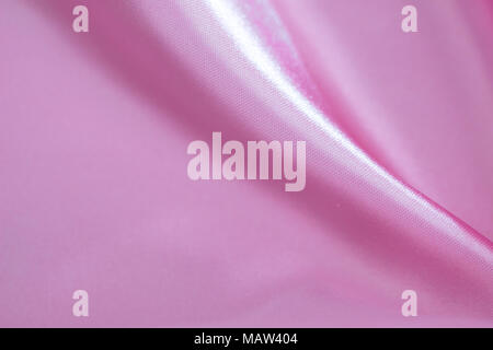 Abstract background of luxury pink wrinkled silk cloth, liquid waves, wavy folds for background texture. Stock Photo