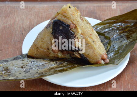 sticky rice steam with pork and salt egg in banana leaf of Chinese Duanwu festival Stock Photo