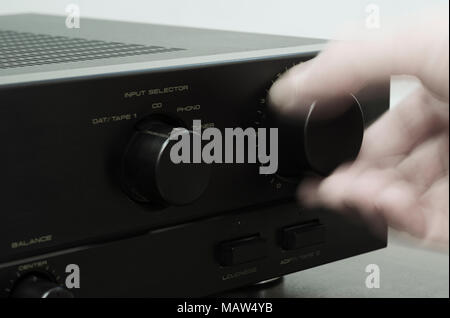 blurred hand adjusting volume control Stock Photo