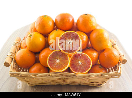 Fresh orange, organic ripe mandarins, pile of orange, sliced orange in wood basket on wooden table background with clipping path. Stock Photo