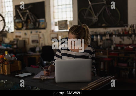 Female mechanic using laptop in workshop Stock Photo
