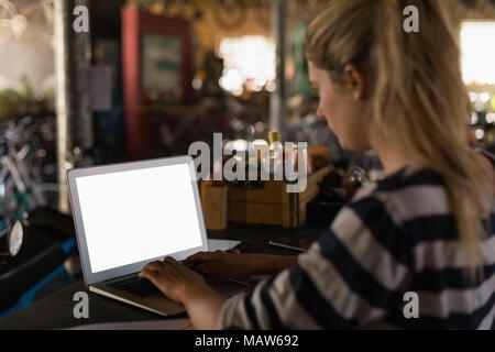 Female mechanic using laptop in workshop Stock Photo
