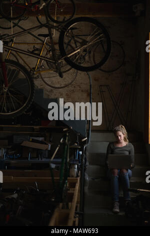 Female mechanic using laptop in workshop Stock Photo