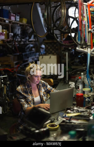 Female mechanic using laptop in workshop Stock Photo