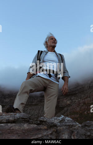 Senior hiker standing on the top of mountain Stock Photo