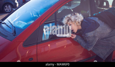 Woman looking on rear view mirror of car Stock Photo