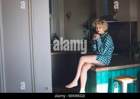 Woman having in kitchen at home Stock Photo