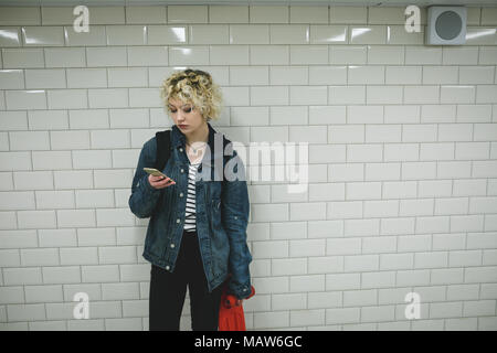 Woman using mobile phone in subway Stock Photo