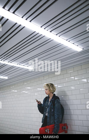 Woman using mobile phone in subway Stock Photo