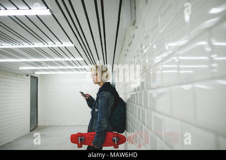 Woman using mobile phone in subway Stock Photo