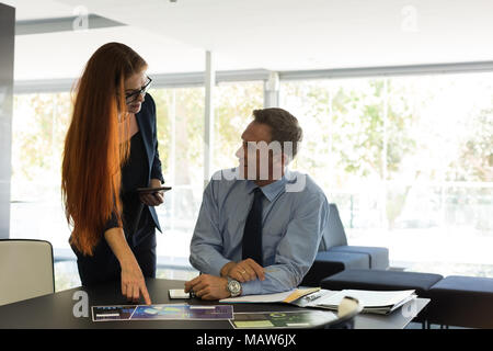 Business colleagues discussing over documents Stock Photo